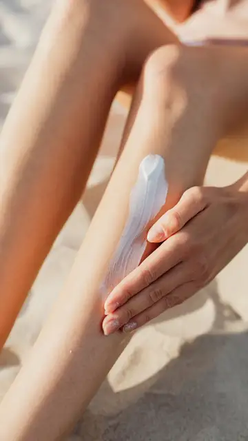 Una persona poniéndose crema de sol Una persona poniéndose crema de sol