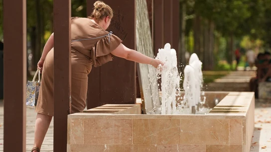 Imagen de una mujer refrescándose en una fuente Imagen de una mujer refrescándose en una fuente