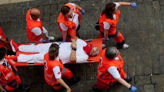 13 July 2026, Spain, Pamplona: An injured man is carried on a stretcher by Red Cross medical staff following the seventh bull run of the 2026 San Fermin Festival in Pamplona, Spain. The run features bulls from the Jos&eacute; Escolar ranch. Photo: Ruben Albarran/ZUMA Press Wire/dpa Ruben Albarran/ZUMA Press Wire/d / DPA 13/07/2026 ONLY FOR USE IN SPAIN