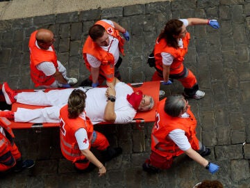 13 July 2026, Spain, Pamplona: An injured man is carried on a stretcher by Red Cross medical staff following the seventh bull run of the 2026 San Fermin Festival in Pamplona, Spain. The run features bulls from the Jos&eacute; Escolar ranch. Photo: Ruben Albarran/ZUMA Press Wire/dpa Ruben Albarran/ZUMA Press Wire/d / DPA 13/07/2026 ONLY FOR USE IN SPAIN