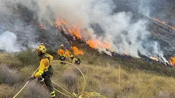 Los bomberos trabajan para apagar las llamas Los bomberos trabajan para apagar las llamas