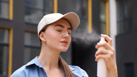 Mujer aplicándose una bruma