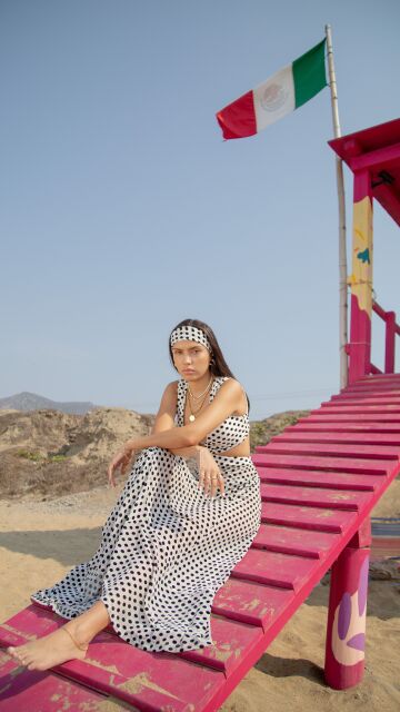 Mujer en la playa con un look de lunares
