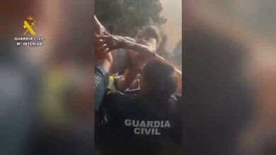 La Guardia Civil saca en volandas a una mujer durante la evacuación por el incendio de Almorox