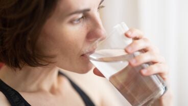 Imagen de archivo de una mujer bebiendo un vaso de agua