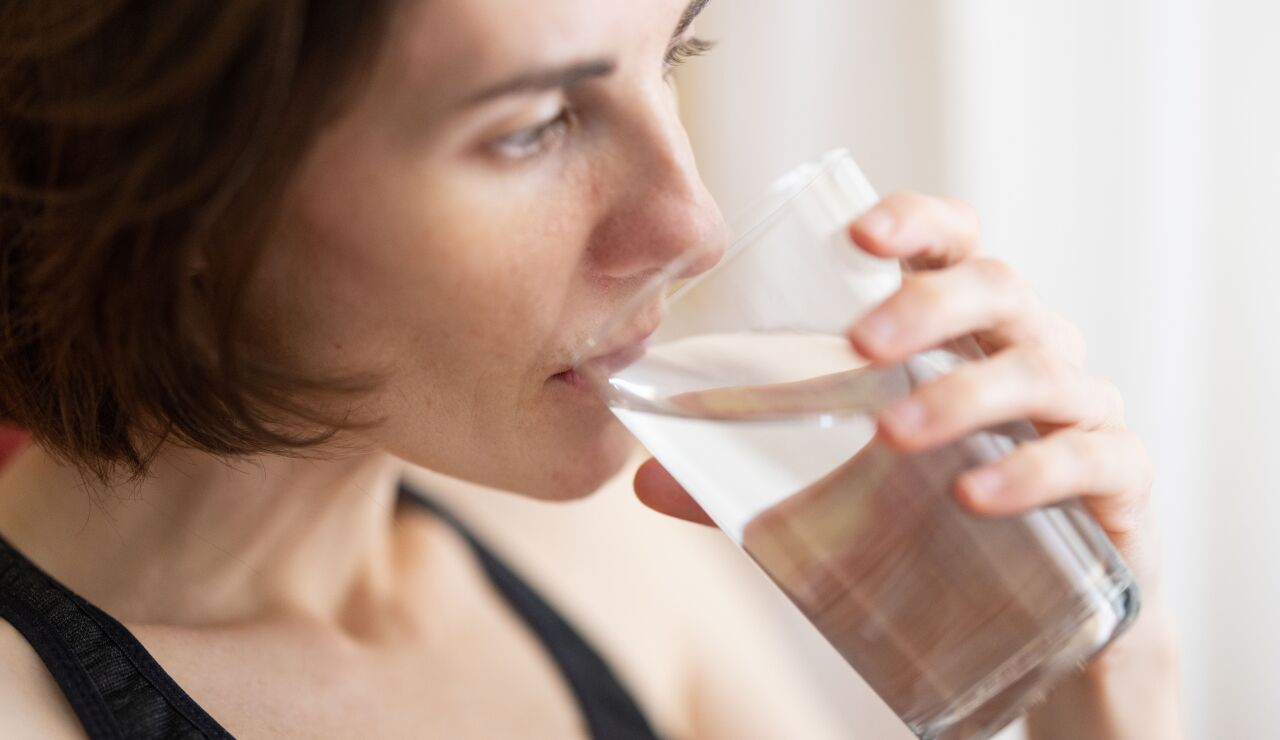 Imagen de archivo de una mujer bebiendo un vaso de agua