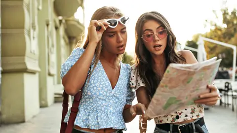 Amigas de viaje mirando un mapa Amigas de viaje mirando un mapa