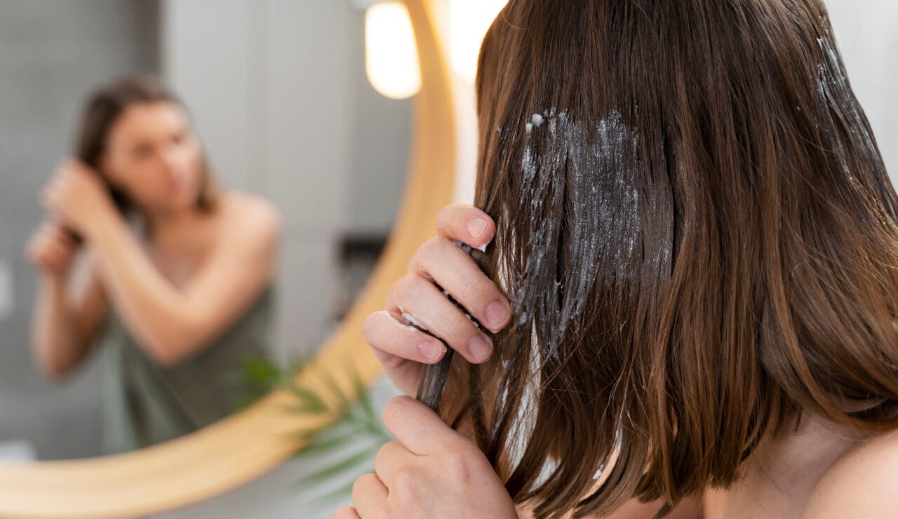 Mujer aplic&aacute;ndose una mascarilla