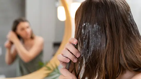 Mujer aplicándose una mascarilla Mujer aplicándose una mascarilla