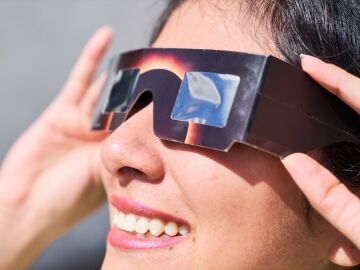 Una mujer con gafas solares para un eclipse Una mujer con gafas solares para un eclipse