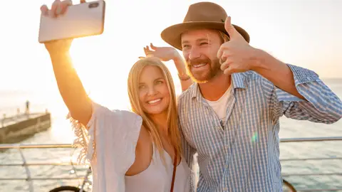 Pareja de vacaciones haciéndose fotos con el móvil Pareja de vacaciones haciéndose fotos con el móvil