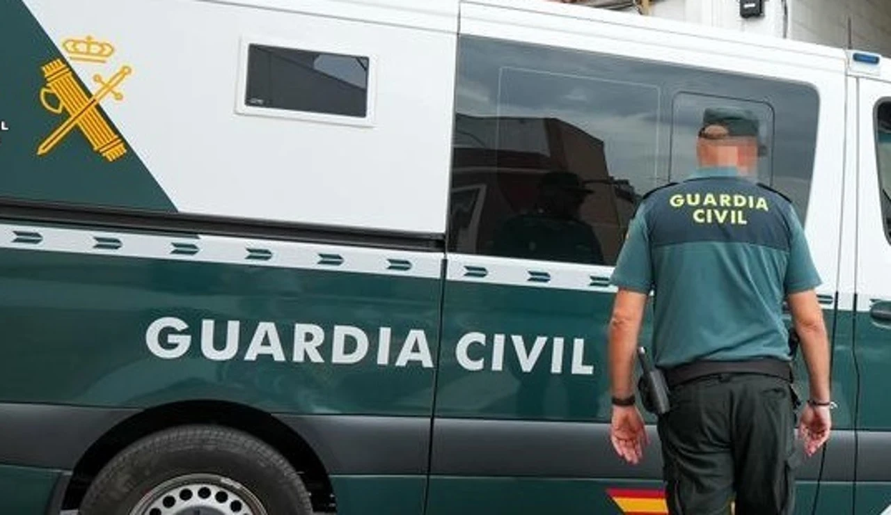 Un agente de la Guardia Civil junto a un vehículo oficial