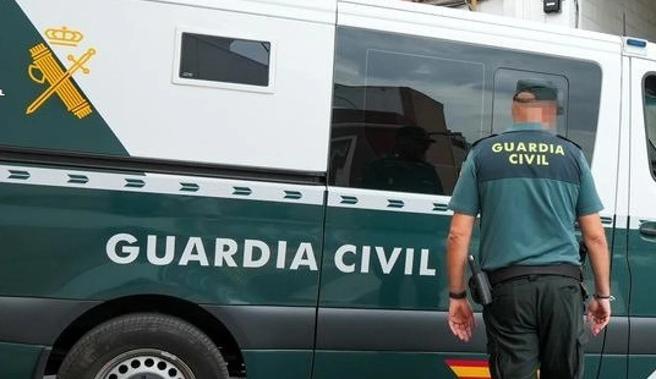 Un agente de la Guardia Civil junto a un vehículo oficial.
