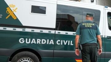 Un agente de la Guardia Civil junto a un veh&iacute;culo oficial.