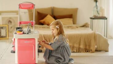 Imagen de una ni&ntilde;a jugando con una cocina de juguete