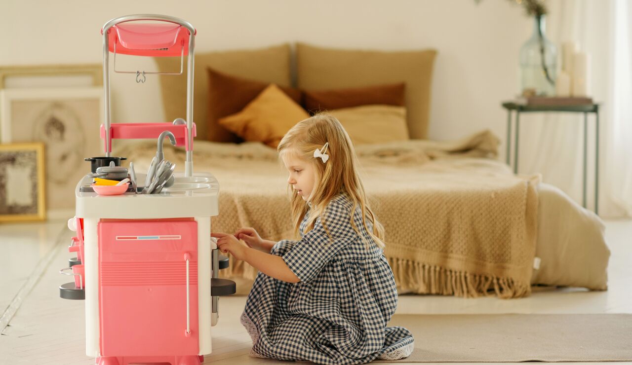 Imagen de una ni&ntilde;a jugando con una cocina de juguete