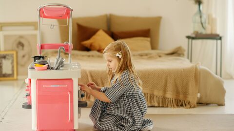 Imagen de una ni&ntilde;a jugando con una cocina de juguete