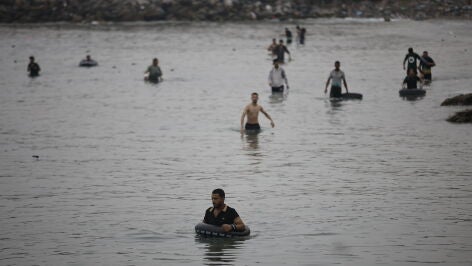 Varios migrantes intentan cruzar a nado la frontera, a 31 de julio de 2026, en Ceuta