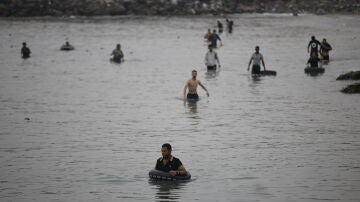 Varios migrantes intentan cruzar a nado la frontera, a 31 de julio de 2026, en Ceuta