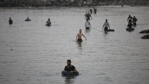Varios migrantes intentan cruzar a nado la frontera, a 31 de julio de 2026, en Ceuta