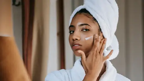 Mujer haciéndose el skincare Mujer haciéndose el skincare