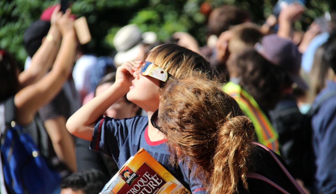 Un ni&ntilde;o mirando un eclipse solar junto a su madre