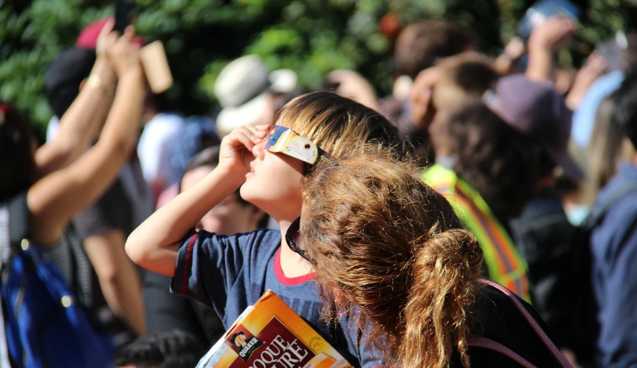 Un niño mirando un eclipse solar junto a su madre