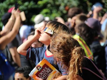 Un ni&ntilde;o mirando un eclipse solar junto a su madre