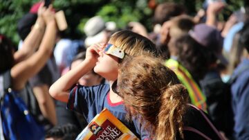 Un ni&ntilde;o mirando un eclipse solar junto a su madre