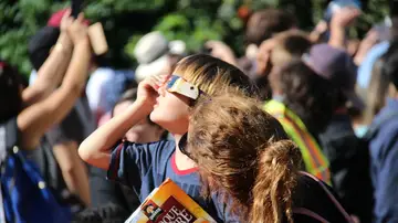 Un niño mirando un eclipse solar junto a su madre Un niño mirando un eclipse solar junto a su madre
