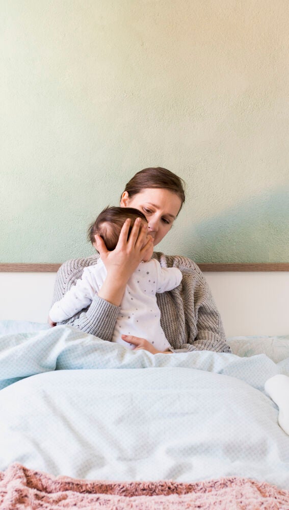 Madre con su bebé en la cama