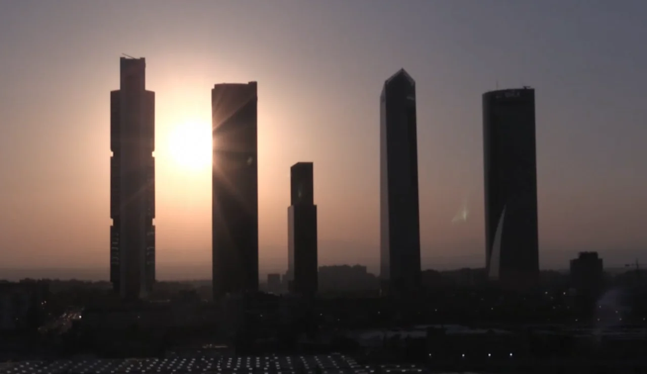 Las cámaras de la Agencia EFE captan desde su sede central en Madrid el eclipse solar de este miércoles tras las Cuatro Torres