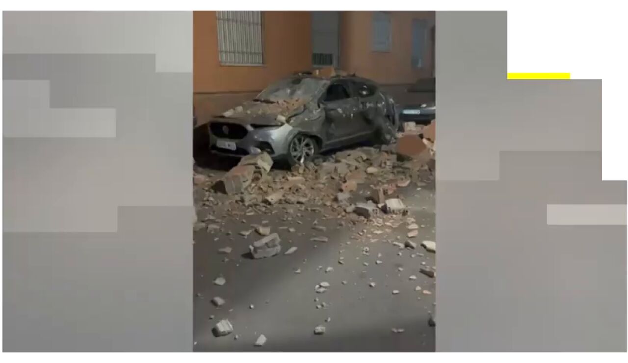 Un coche destrozado tras caer sobre &eacute;l restos de un edificio por el terremoto de Granada.