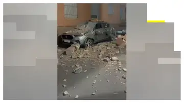 Un coche destrozado tras caer sobre él restos de un edificio por el terremoto de Granada. Un coche destrozado tras caer sobre él restos de un edificio por el terremoto de Granada.