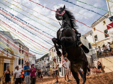 Jinetes a lomos de sus caballos inician las fiestas de Sant Bartomeu este lunes en Ferreries con tres vueltas alrededor del Pla de l&rsquo;Esgl&eacute;sia