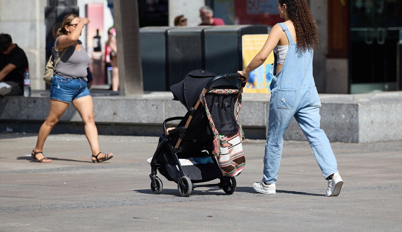 Imagen de una mujer con un carrito de beb&eacute; 