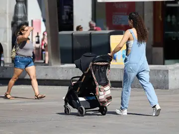 Imagen de una mujer con un carrito de bebé Imagen de una mujer con un carrito de bebé