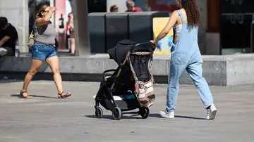 Imagen de una mujer con un carrito de bebé Imagen de una mujer con un carrito de bebé