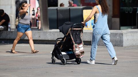 Imagen de una mujer con un carrito de beb&eacute; 
