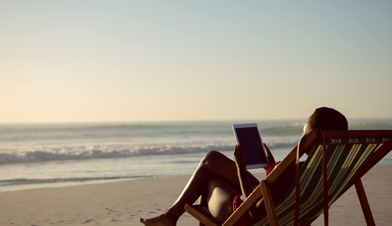 Imagen de una mujer en la playa con una tablet
