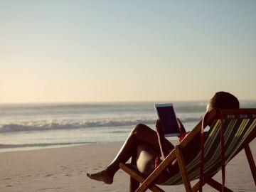 Imagen de una mujer en la playa con una tablet