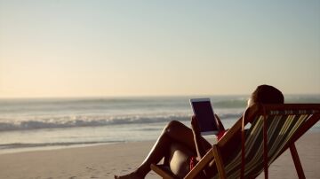 Imagen de una mujer en la playa con una tablet