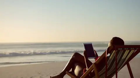 Imagen de una mujer en la playa con una tablet Imagen de una mujer en la playa con una tablet