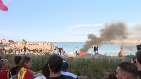 Los ceut&iacute;es queman el campamento de los migrantes de la playa del Trampol&iacute;n