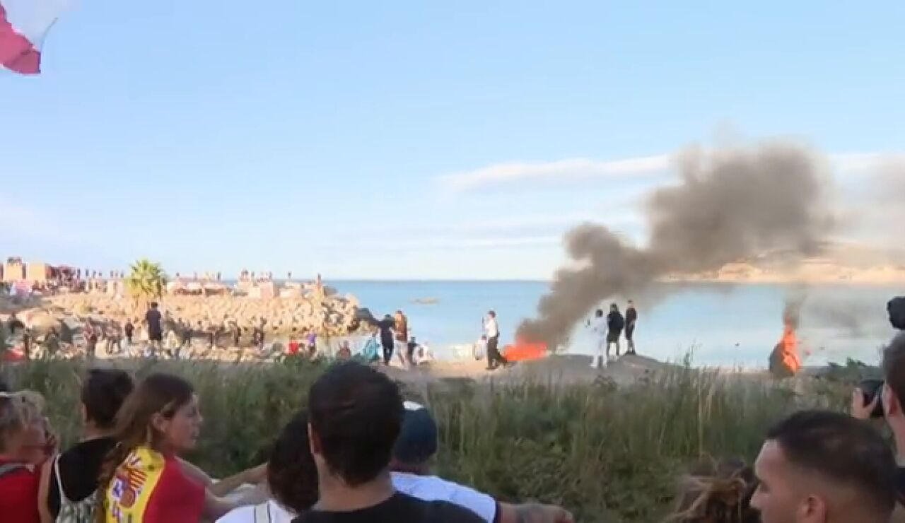 Un grupo de ceut&iacute;es queman el campamento de los migrantes de la playa del Trampol&iacute;n