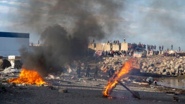 Mobiliario urbano y enseres arden durante una manifestaci&oacute;n para protestar por la situaci&oacute;n provocada por la llegada masiva de migrantes