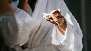 Mujer con un cosm&eacute;tico en la mano