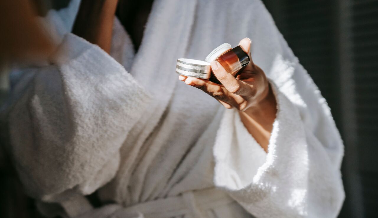 Mujer con un cosm&eacute;tico en la mano