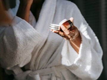 Mujer con un cosm&eacute;tico en la mano