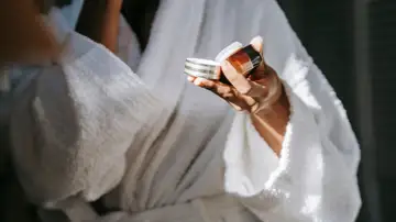 Mujer con un cosmético en la mano Mujer con un cosmético en la mano